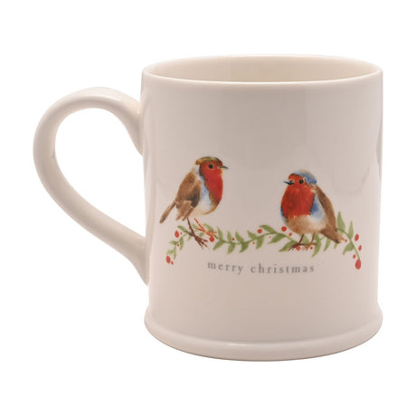 White stoneware mug with two watercolour-style robins on a berry branch and "merry christmas" text in grey lowercase lettering, shown with handle on a plain background.