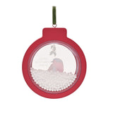 Round red bauble-shaped wall plaque with a clear window showing a watercolour robin, holly sprig, and faux snow beads, hung with a green ribbon on a white background.