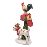 Christmas resin ornament featuring a cockerel perched on a snow-capped red mailbox with wrapped parcels, beside a white dog holding a Santa letter, set on a white background.