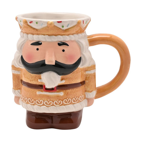 Ceramic mug shaped as a gingerbread nutcracker, with a white icing crown rim, black moustache, curled beard and brown tunic, set against a plain white background.