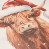 Rectangular Christmas placemat from the set of 4 featuring a close-up Highland cow in a red, white-trimmed Santa hat, with shaggy ginger-brown fur and falling snowflakes on a white background.