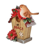 Resin robin bird house figurine with a brown wood-effect base reading "Peace", red glittered roof, bow, holly, and poinsettia, on a white background.