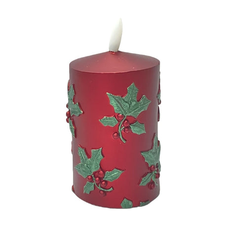 Embossed Holly Leaf Pillar LED Candle, 11cm, round metallic red body with raised green holly leaves and red berries, flame-tip top, on a plain white background.