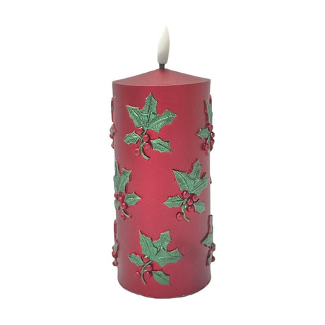 Embossed Holly Leaf Pillar LED Candle, 15.5cm round red plastic pillar with raised green holly leaves and red berry clusters, pale flame-shaped tip, on a plain white background.