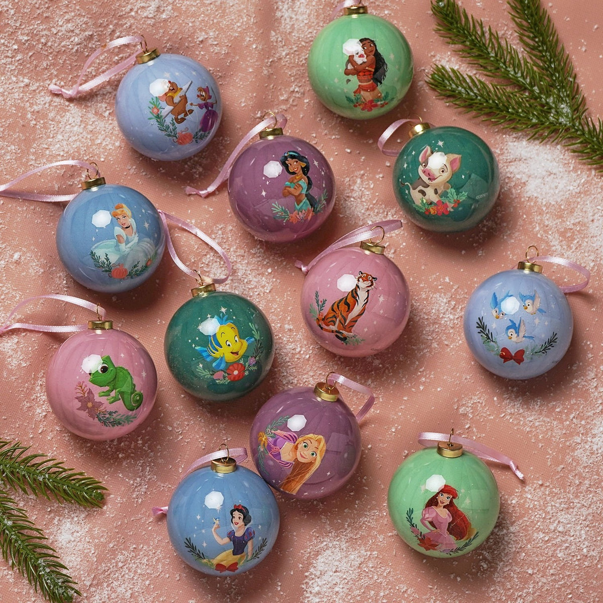Set of 12 round glossy 6cm baubles featuring printed Disney princesses and sidekicks, including Moana, Ariel, Rapunzel, Snow White and Jasmine, in muted multicoloured tones with ribbon hangers.