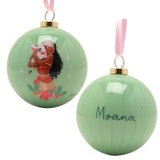 Two glossy green round baubles from the set show Moana embracing Pua framed by florals, with a pink ribbon hook and "Moana" script on the reverse, pictured on a white background.