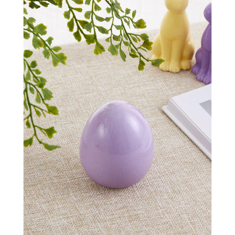 Yaypan Decorative Egg in lilac, a glossy ceramic egg-shaped ornament on a woven beige surface, styled with greenery and small animal figurines in the background.