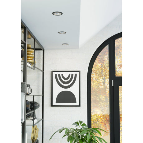 Yebra Smart Colour Changing LED Downlight in black and silver, shown recessed into a white ceiling with two additional matching downlights in a bright living space.