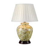 The Yellow Flowers 1 Light Table Lamp - Yellow & Purple showcases a floral-patterned ceramic base in green tones reminiscent of Chinese porcelain, complemented by a pleated white lampshade. Resting on a dark wooden stand, it offers an elegant and classic appearance.