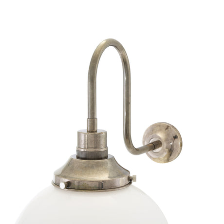 Yerevan swan neck wall light with a curved antique brass arm and round opal glass globe, shown against a plain white background.