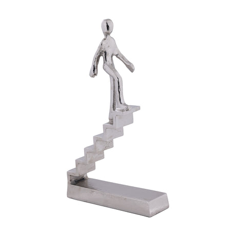 Zadiwin Figurine 39cm silver aluminium sculpture of a stylised figure climbing a staircase on a rectangular base, lightly textured nickel finish, plain white background.