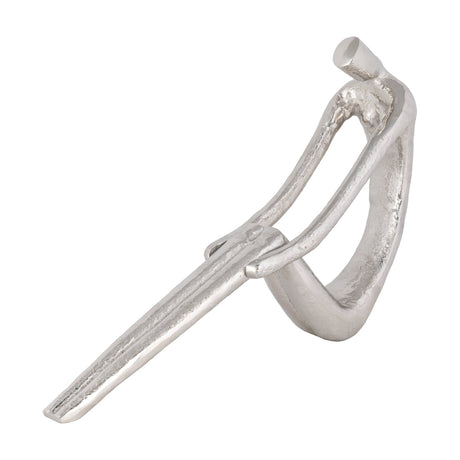 Zadiwin Sculpture in silver-finished aluminium, an abstract seated figure with a looped body, small cylindrical head and elongated outstretched legs, shown on a plain white background.