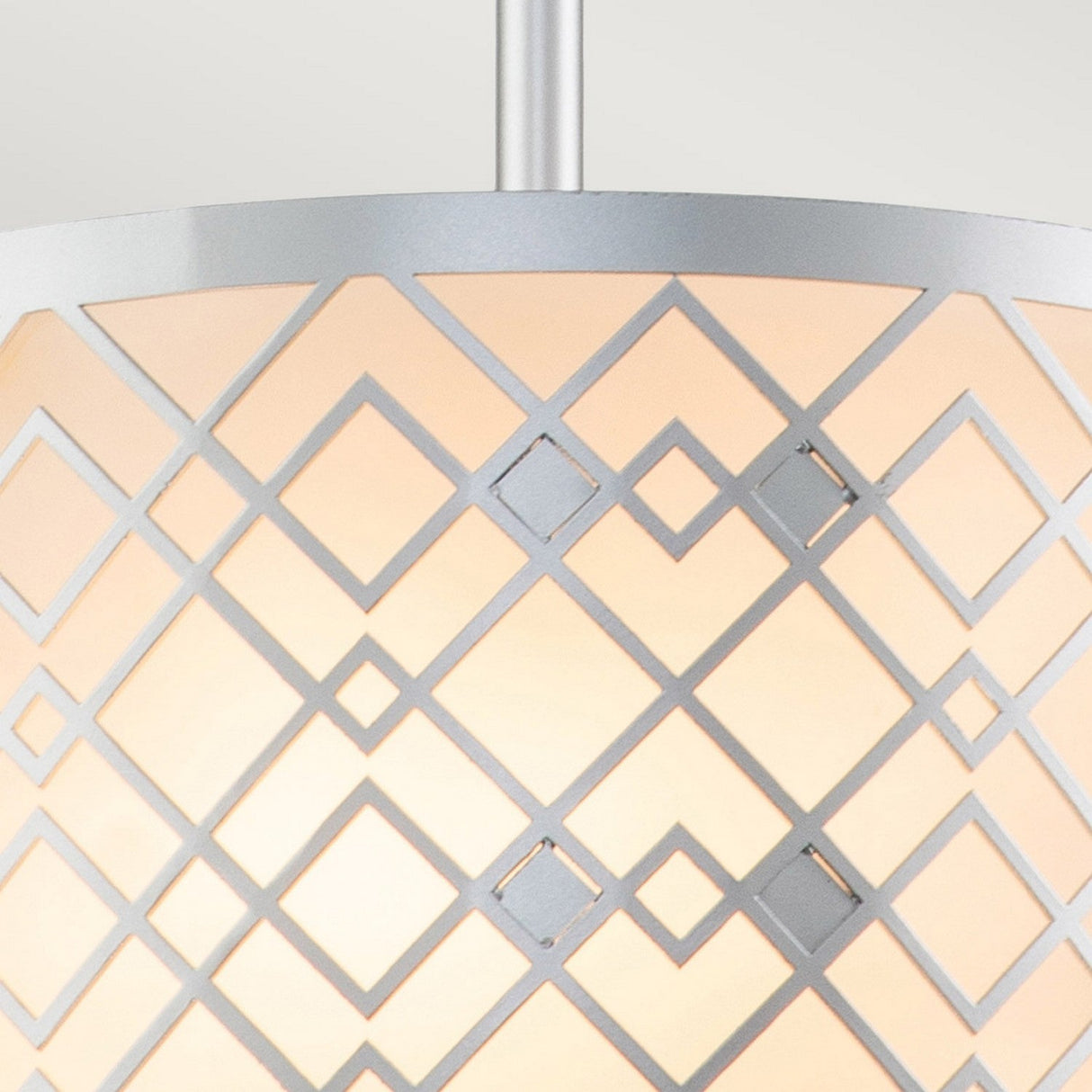 Close-up of the Ziggy 1 Light Duo-Mount Small Pendant/Semi-Flush in Lacquered Silver, featuring a geometric diamond pattern. The metal frame encases a soft, warm light, showcasing modern lighting and elegant design against a simple, neutral background.