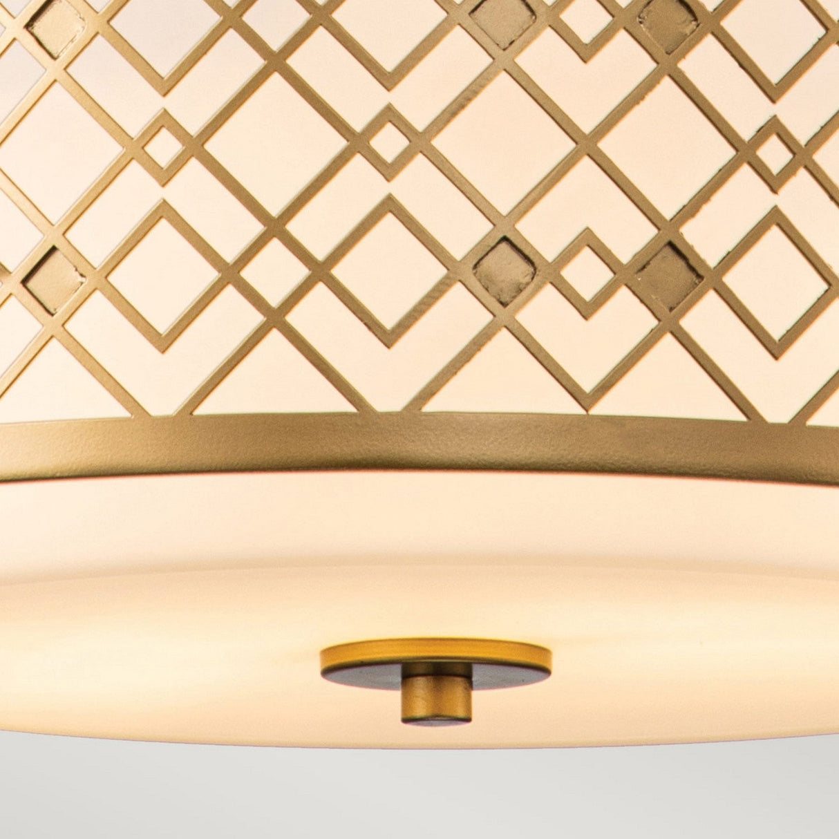 A close-up view of the Ziggy 2 Light Duo-Mount Medium Pendant/Semi-Flush showcases its geometric lattice pattern in a lacquered gold finish. This contemporary fixture, with its adjustable height, offers versatility and features a smooth sheen on the bottom part that creates an elegant, warm ambiance.