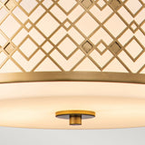 A close-up view of the Ziggy 2 Light Duo-Mount Medium Pendant/Semi-Flush showcases its geometric lattice pattern in a lacquered gold finish. This contemporary fixture, with its adjustable height, offers versatility and features a smooth sheen on the bottom part that creates an elegant, warm ambiance.