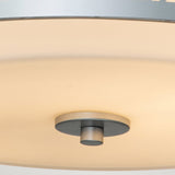 Close-up of the Ziggy 2 Light Medium Flush in lacquered silver, showcasing an opal glass shade. The fixture casts a soft and diffused light, creating a warm glow.